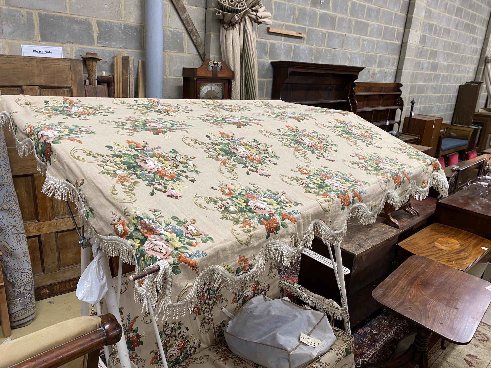 A vintage metal garden swing seat with printed floral covers, width 170cm, depth 104cm, height 180cm